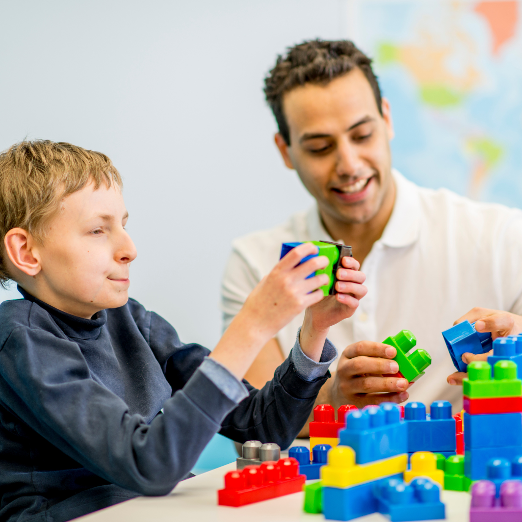 Services An adult and a child playing with LEGO. Physical support needs QCG (Quality Care group)