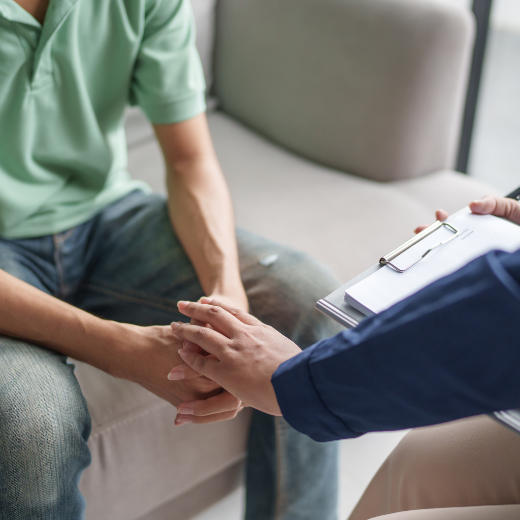 Services A man in a polo shirt at a therapy session for mental health support QCG